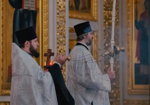 Orthodox priest reading by candlelight